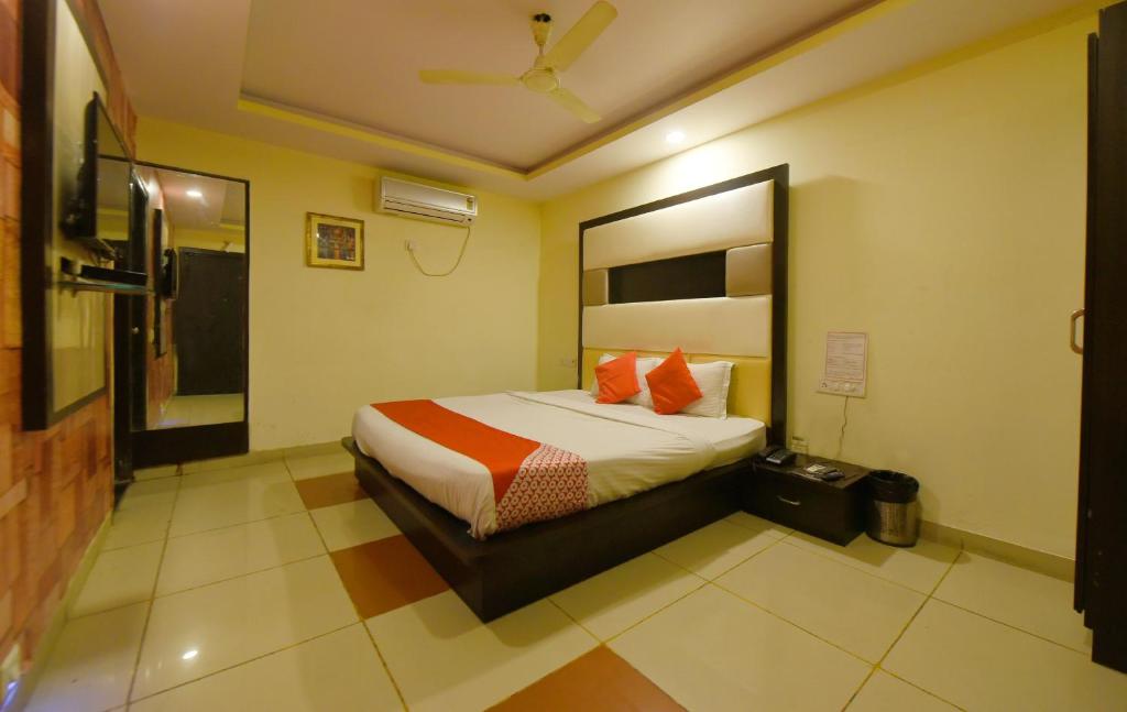 a bedroom with a bed with orange pillows at Collection O Tip Top in Jaipur