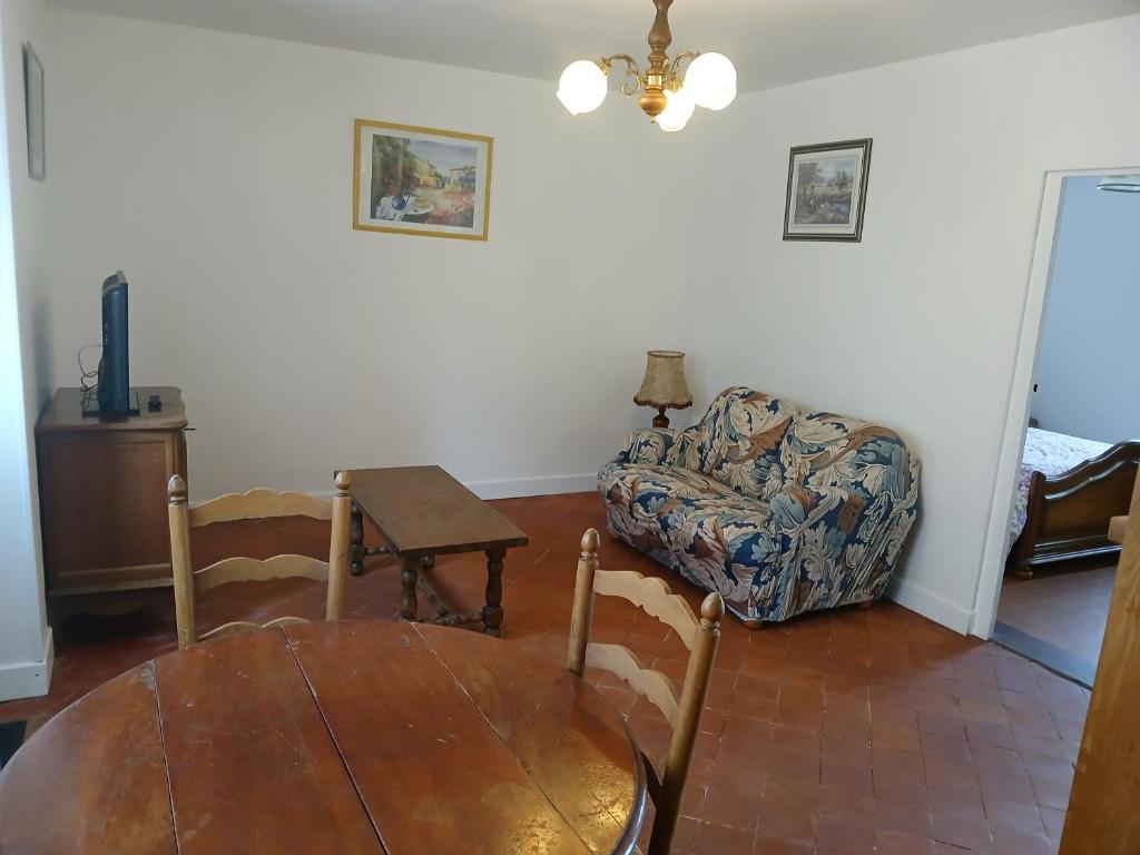 a living room with a couch and a table at La maison de Marguerite in Mont-Saint-Jean
