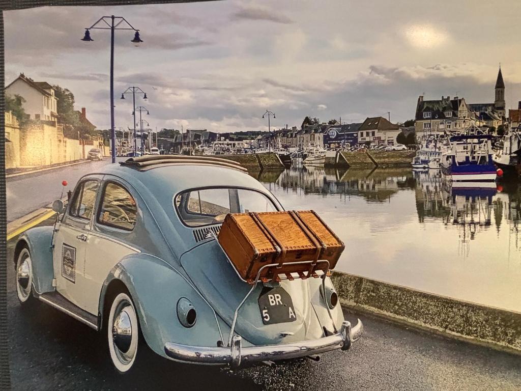 une vieille voiture bleue et blanche avec des bagages à l'arrière dans l'établissement Chambre Beetle close to Bayeux - Normandie, à Monceaux-en-Bessin
