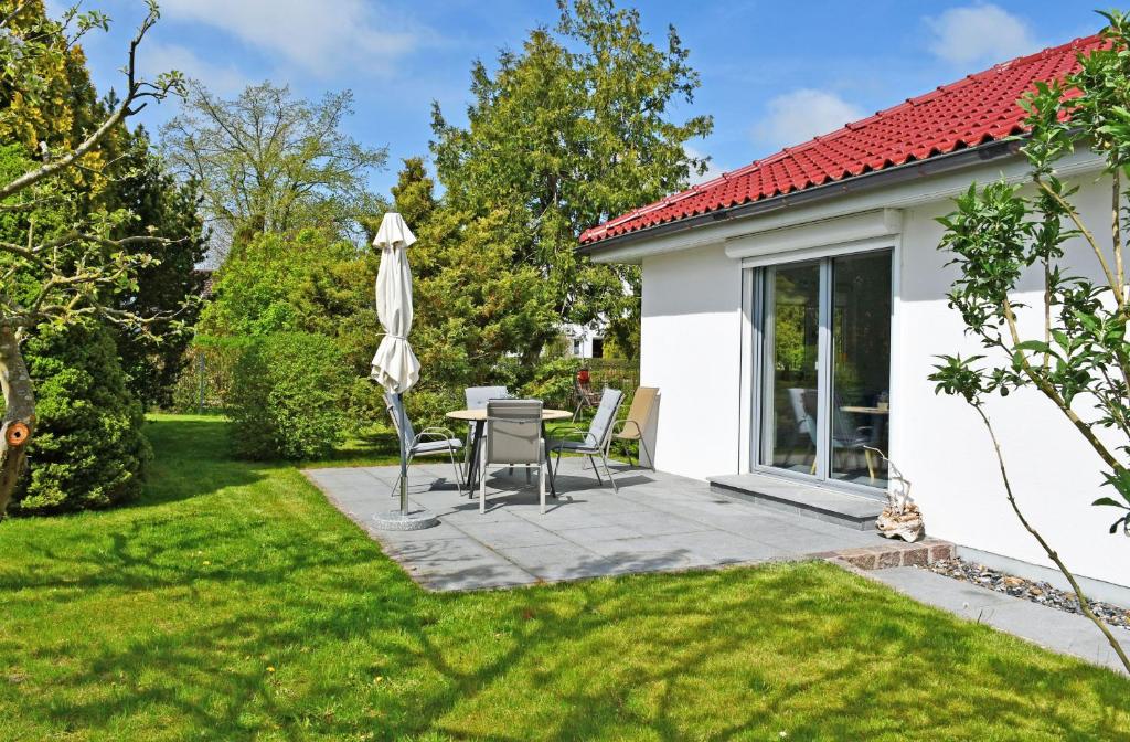 ThesenvitzFerienhaus mit Sauna u Terrasse im Zentrum von Rügen的带遮阳伞、桌椅的露台