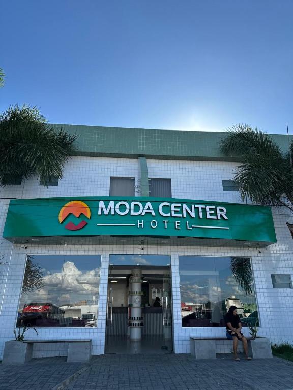 a woman sitting in front of a moda center hotel at Moda Center Hotel in Santa Cruz do Capibaribe