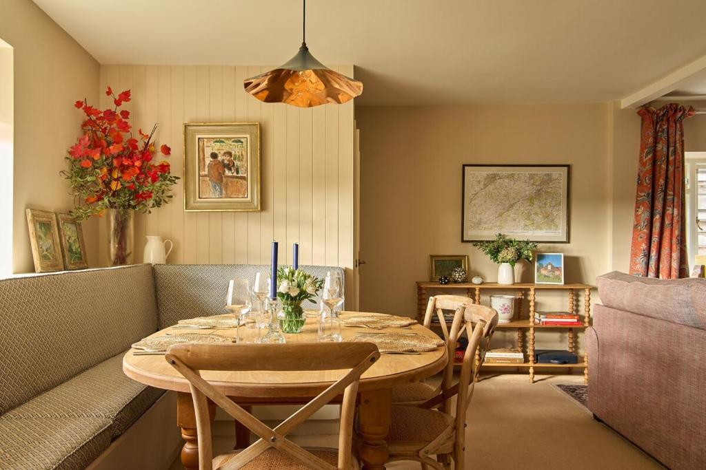 une salle à manger avec une table et un canapé dans l'établissement Haybarn Cottage, à Alton