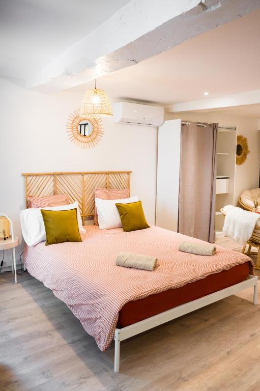 - une chambre dotée d'un grand lit avec des oreillers verts et blancs dans l'établissement Le Sauvignon, à Bergerac