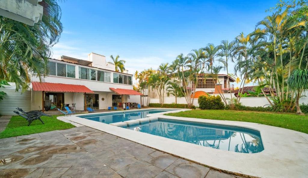 a swimming pool in front of a house at Tranquilo - Private Pool Near Beach Sleeps 16 in Ixtapa