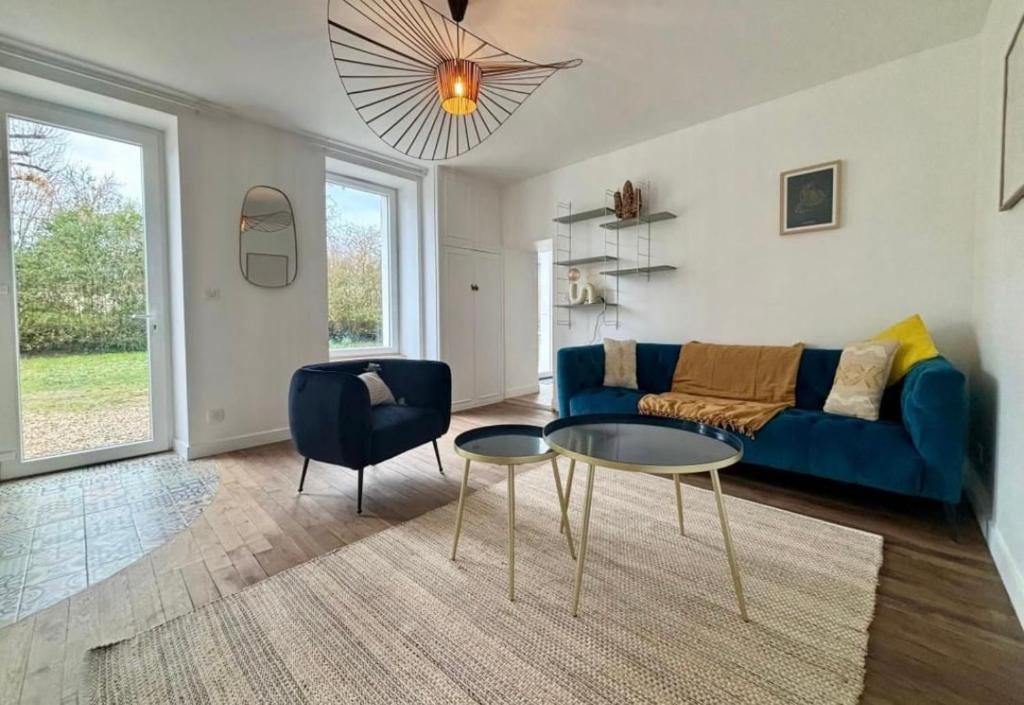 un salon avec un canapé bleu et une table dans l'établissement Maison de ville esprit campagne 3 chambres, à Poitiers