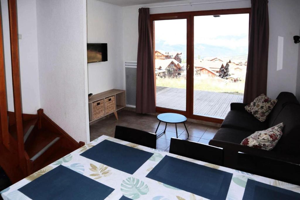 a living room with a table and a couch at Chalet La Combe D Or - Chalet mitoyen en résidence de standing MAE-6244 in Les Orres