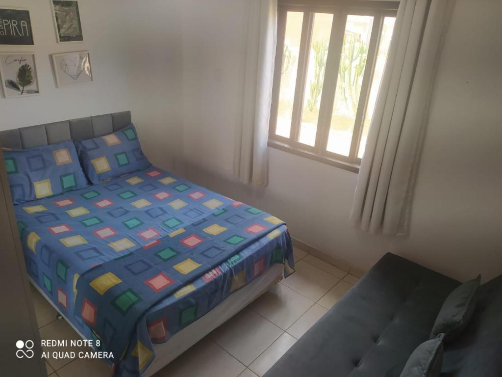 a bedroom with a bed and a window and a chair at Casa Praia Rasa in Búzios