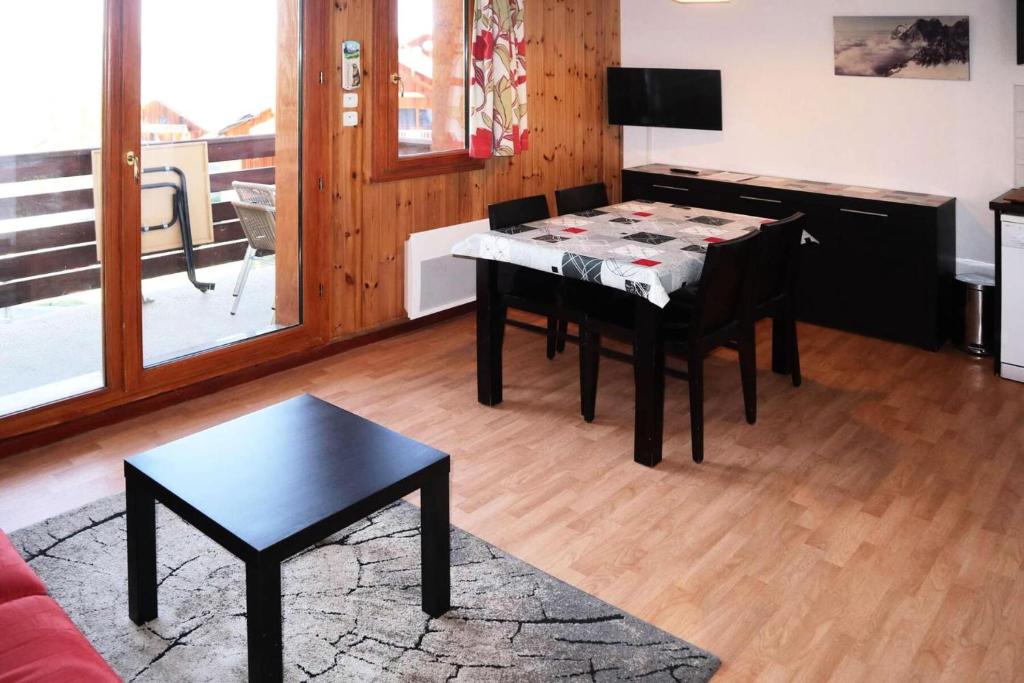 un salon avec une table, des chaises et une télévision dans l'établissement Residence La Combe D Or - Appartement en résidence de standing MAE-6284, aux Orres