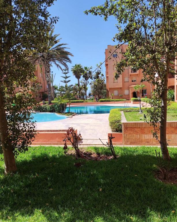 a swimming pool in the middle of a park at Ricoflores Mansouria in Mansouria