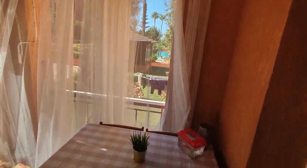 曼苏里亚Ricoflores Mansouria的一个房间里有一张桌子，一扇窗户，窗户旁边还有一张桌子和一个桌子