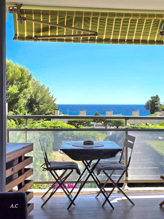 une table et des chaises sur un balcon avec vue sur l'océan dans l'établissement Les Embruns - Super Vue mer, refait à neuf avec parking privée à La Ciotat - BY AURAconciergerie, à La Ciotat