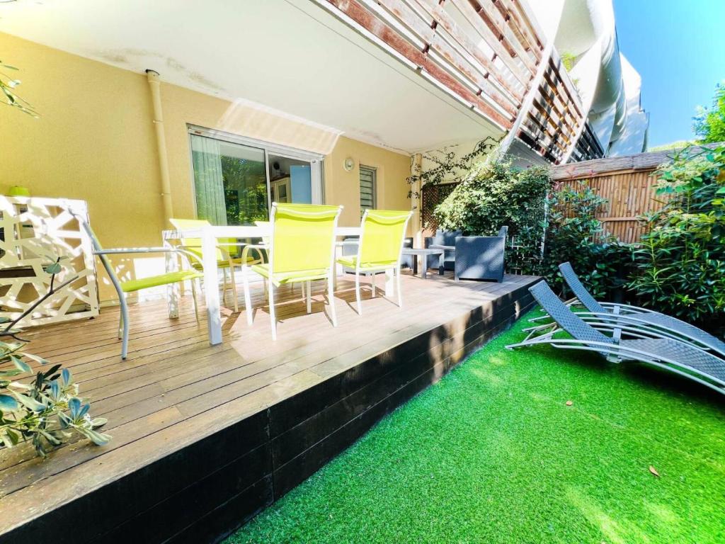 une terrasse en bois avec des chaises jaunes et une table dans l'établissement Villegiales Tee1 - 2 pièces cabine en rez de jardin avec piscine clim MAE-6313, à La Grande Motte