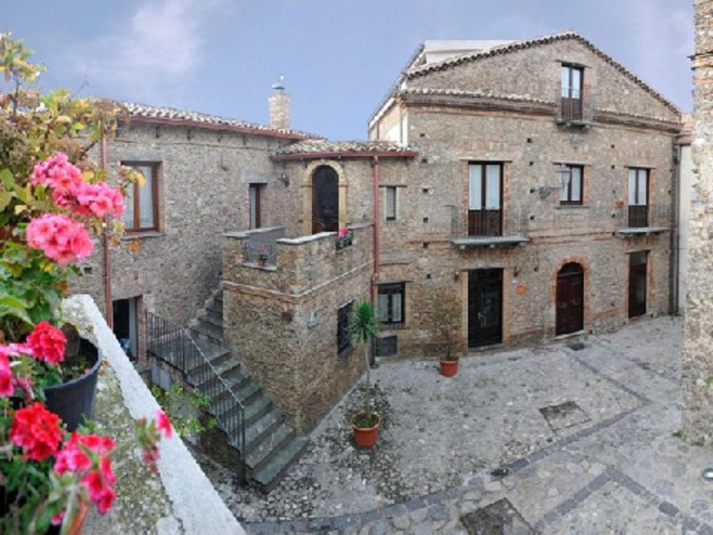 un grande edificio in pietra con una scala di fronte di b&b La casa di Ely a Marcellinara