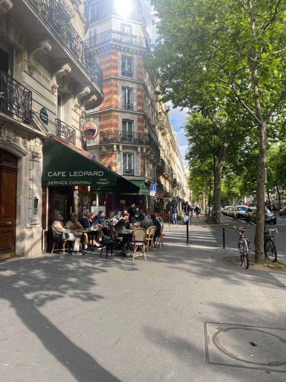 Un groupe de personnes assises à des tables dans une rue de la ville dans l'établissement Bright 3 rooms in Paris 11th, à Paris