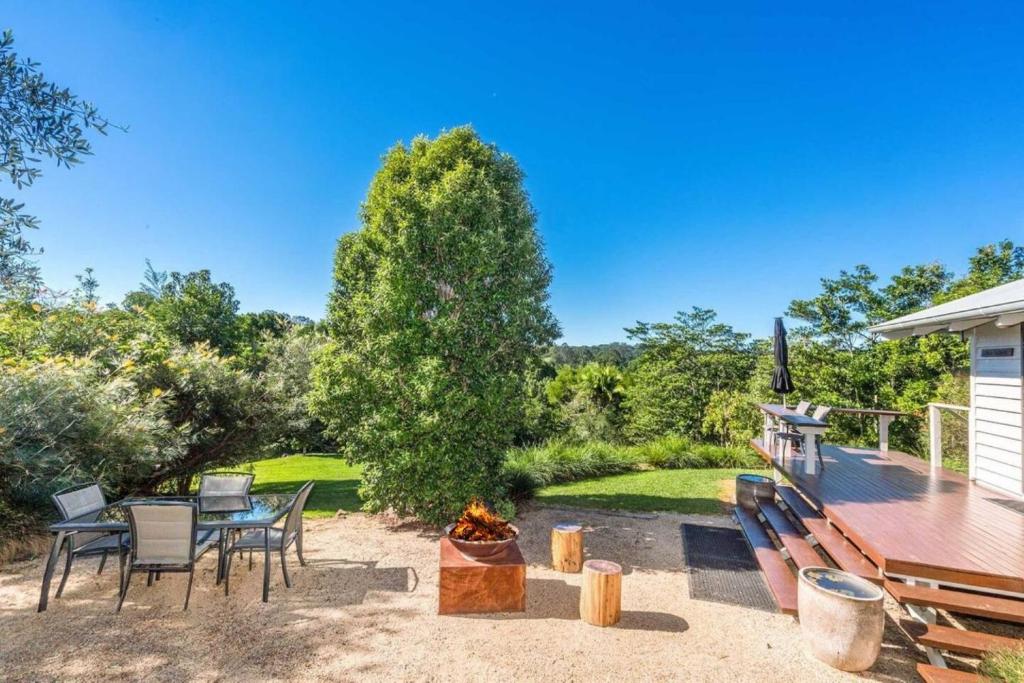 a patio with a table and chairs and a fire pit at Twin Tallows - secluded couples retreat in Bangalow