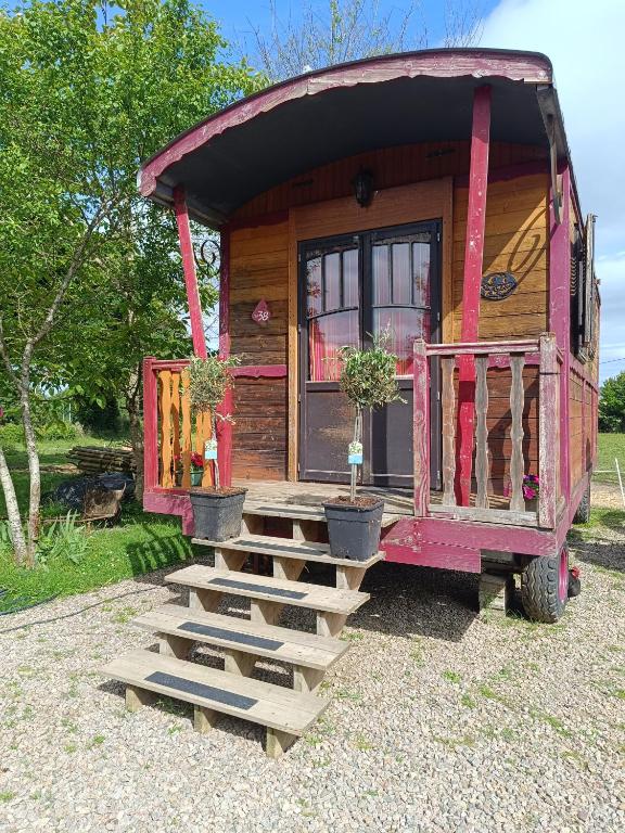 une petite maison avec des escaliers en face de celle-ci dans l'établissement La roulotte la tribu deschpouss, à Saint-Christophe-en-Boucherie