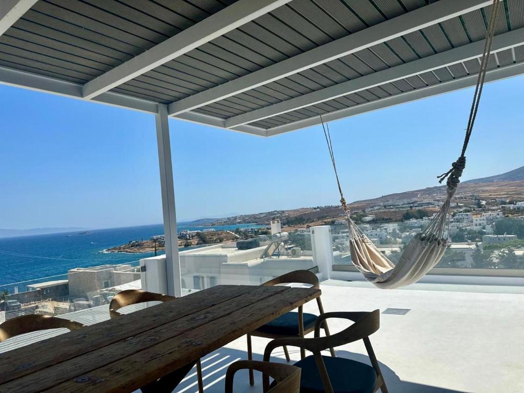 a porch with a hammock and a view of the ocean at Blue Rock Villa in Piso Livadi