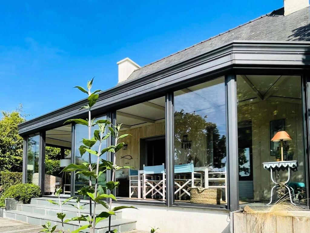 une extension en verre d'une maison avec un patio dans l'établissement Résidence P27-pleumeur Bodou - Kerewan maison vue mer classée 3 étoiles MAE-3494, à Pleumeur-Bodou