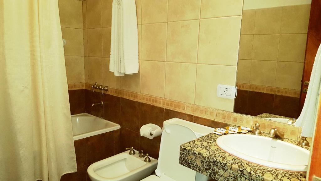 
a bathroom with a toilet, sink, and bathtub at Altoparque Hotel Salta in Salta
