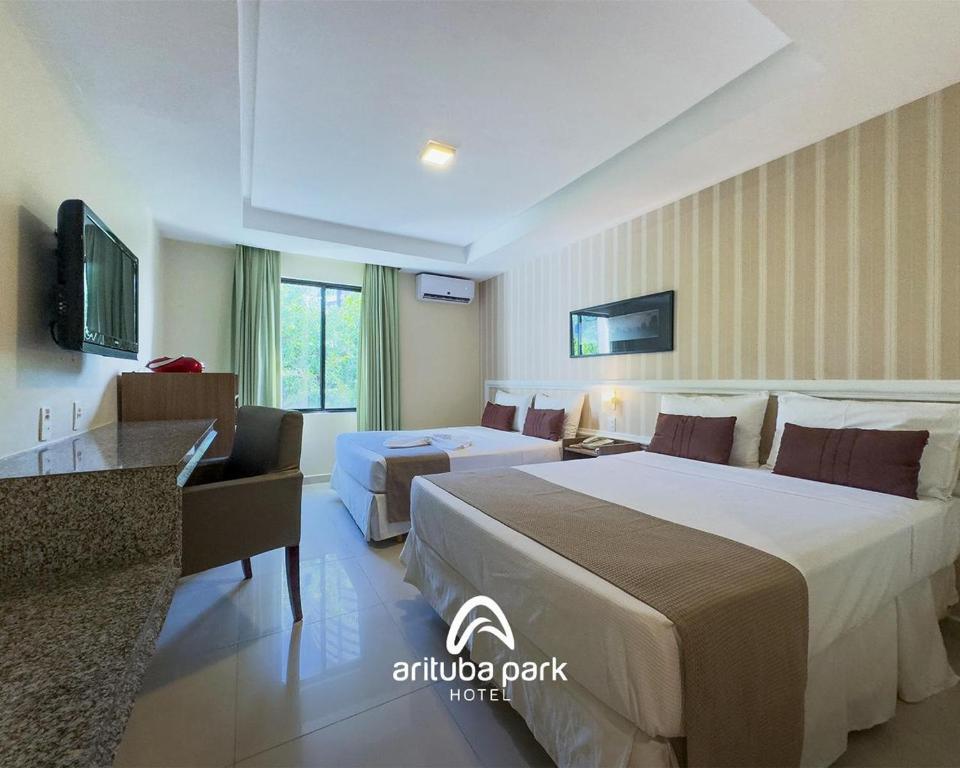 a hotel room with two beds and a desk at Arituba Park Hotel in Natal