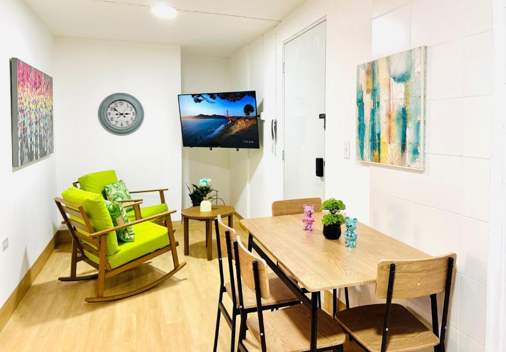 a dining room with a table and chairs and a clock at Chic full apt in Heart of City in Panama City
