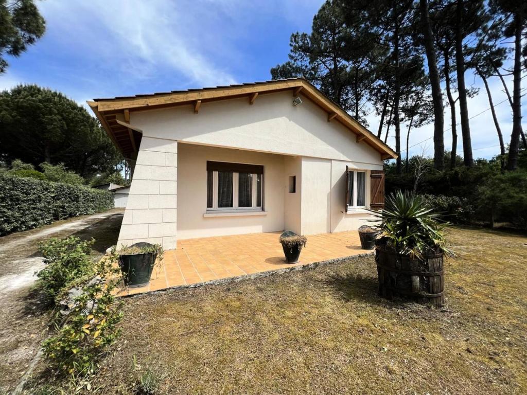 une petite maison dans une cour avec dans l'établissement Résidence 113-montalivet - 113 - Maison de famille proche de l'océan MAE-7121, à Vendays-Montalivet