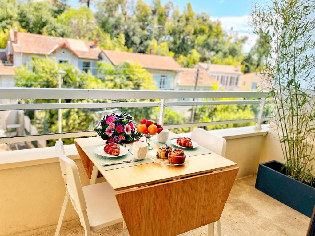 une table avec une assiette de nourriture sur un balcon dans l'établissement Cannes Breeze, à Cannes