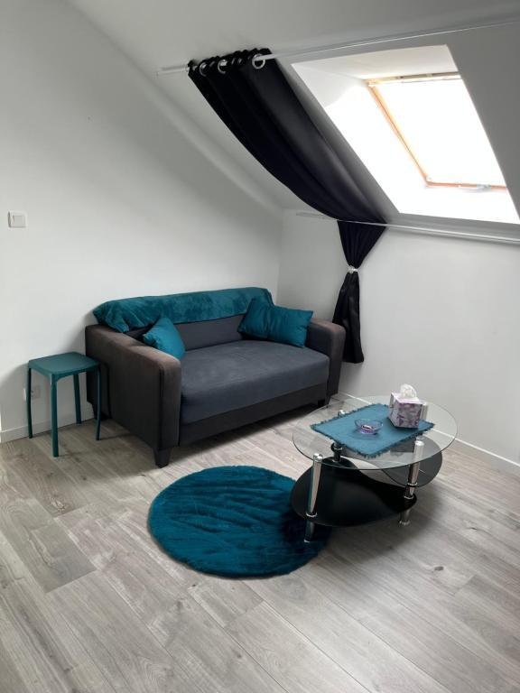 un salon avec un canapé et une table en verre dans l'établissement Violette, à La Souterraine