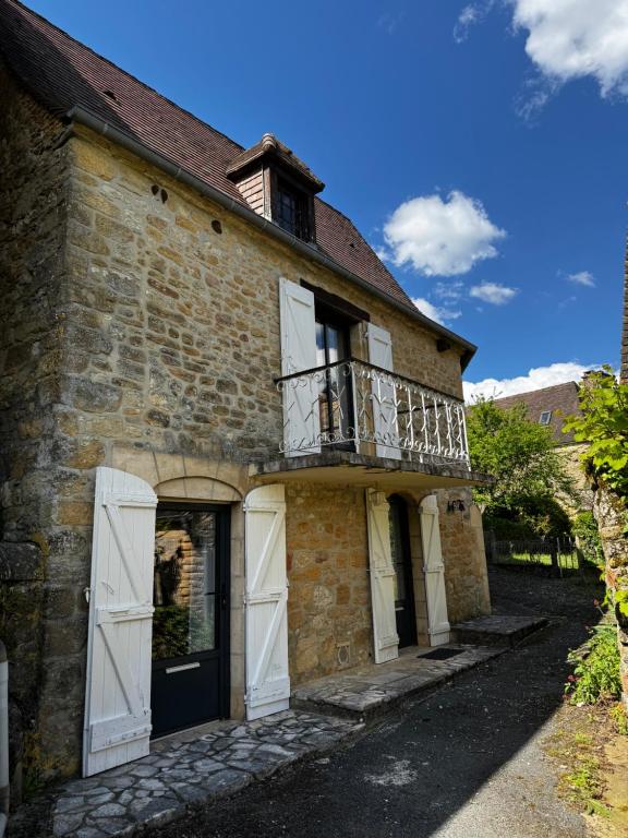 Cette ancienne maison en pierre possède un balcon sur le côté. dans l'établissement Louhmari, à Sarlat-la-Canéda