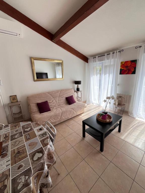 un salon avec un canapé et une table dans l'établissement Maison grand confort Port Camargue LE GRAU DU ROI proche ESPIGUETTE, au Grau-du-Roi