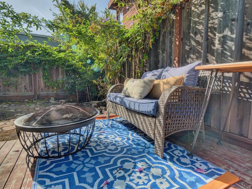 een terras met een rieten stoel en een vuurplaats bij Central Berkeley Garden Oasis in Berkeley