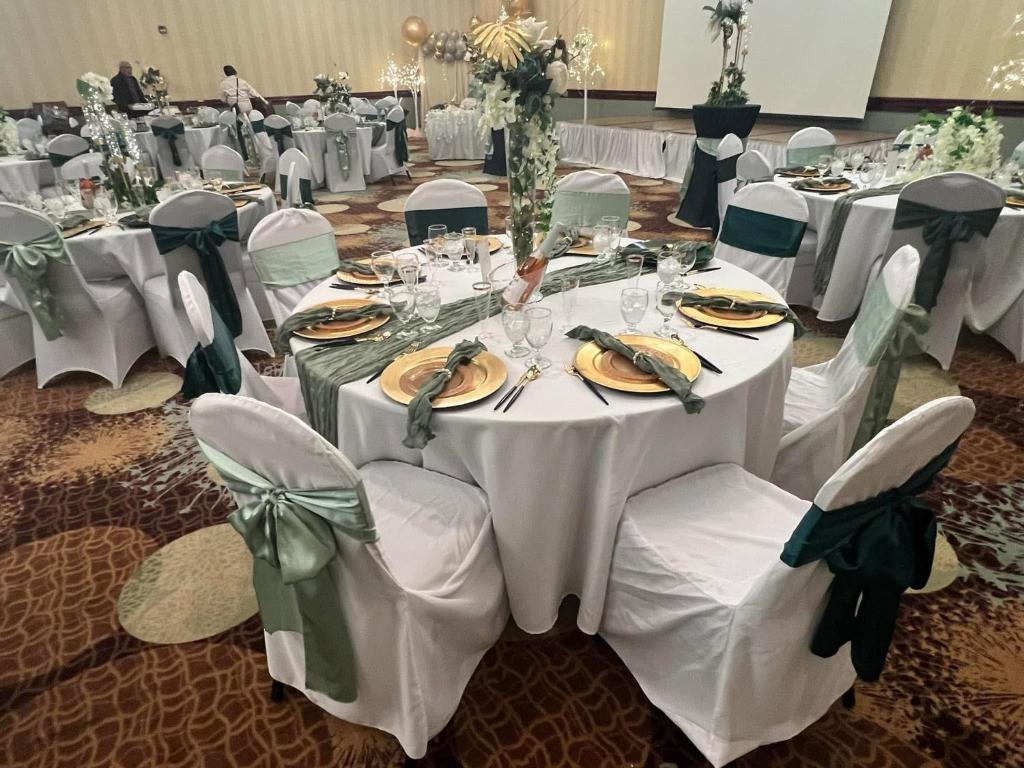 a banquet hall with white tables and white chairs at Lynchburg Grand Hotel in Lynchburg