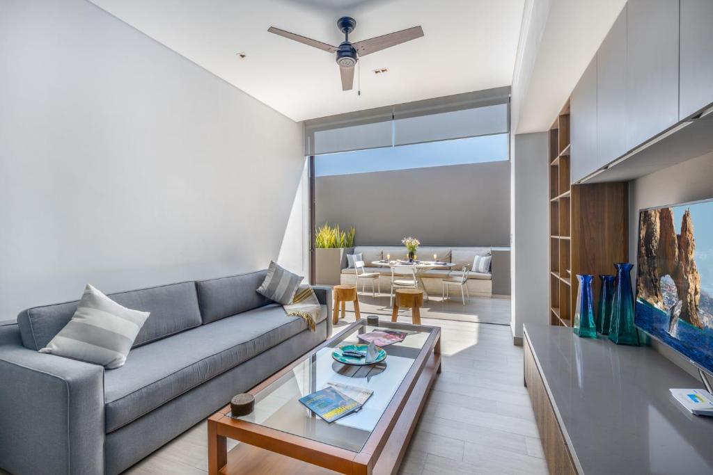a living room with a couch and a table at 2 BR Cabo Marina Walk to Beach & Private Jacuzzi in Cabo San Lucas