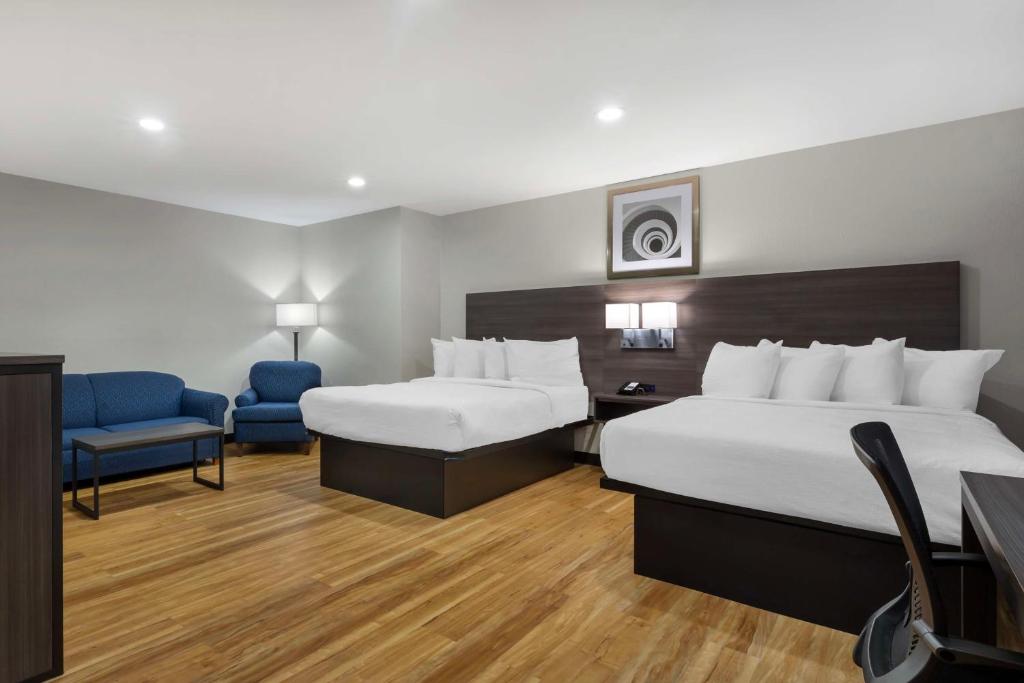 a hotel room with two beds and a chair at Best Western Mystic Hotel in Mystic