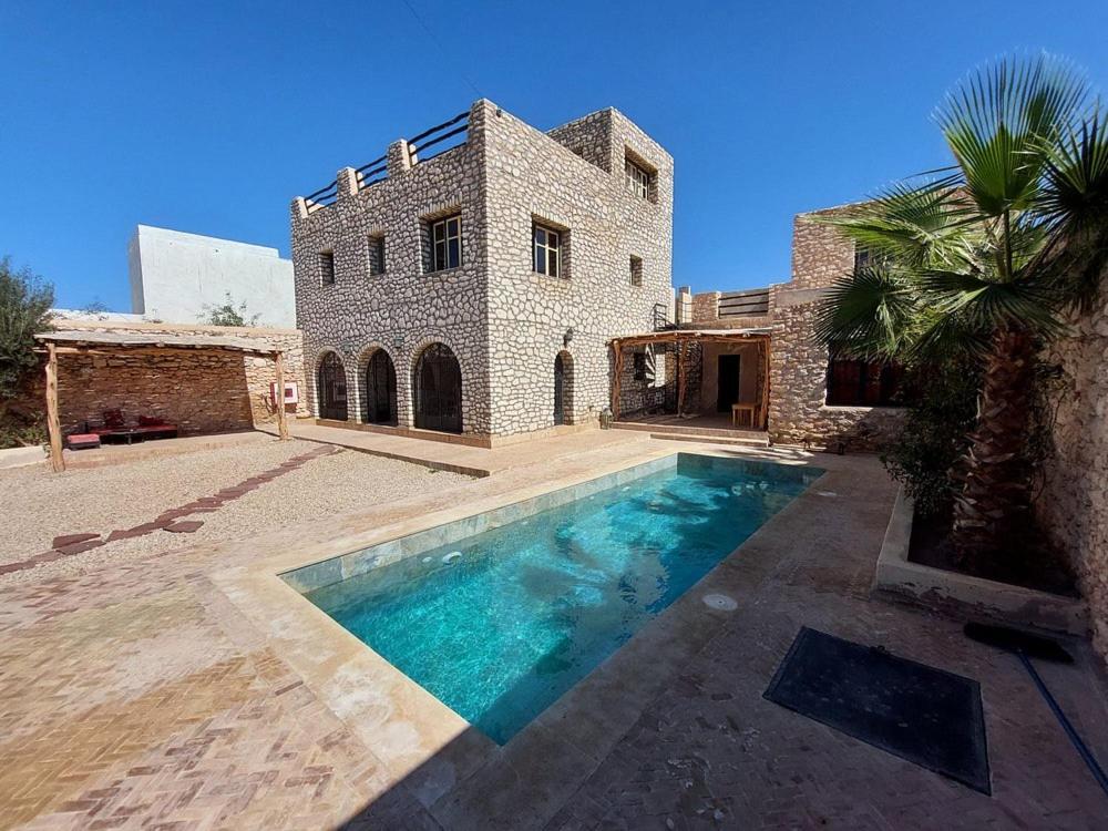 a house with a swimming pool in front of a building at Villa Des Arts in Essaouira