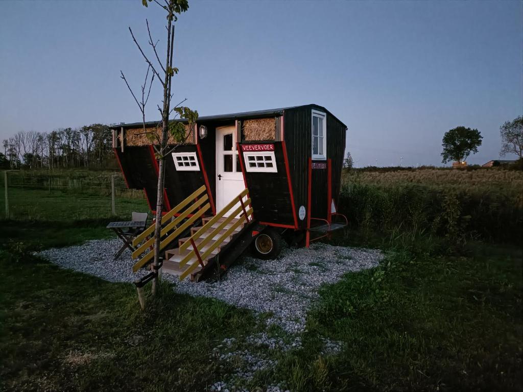 a tiny house sitting on top of a field at Farmstay Zijperdijk in Anna Paulowna