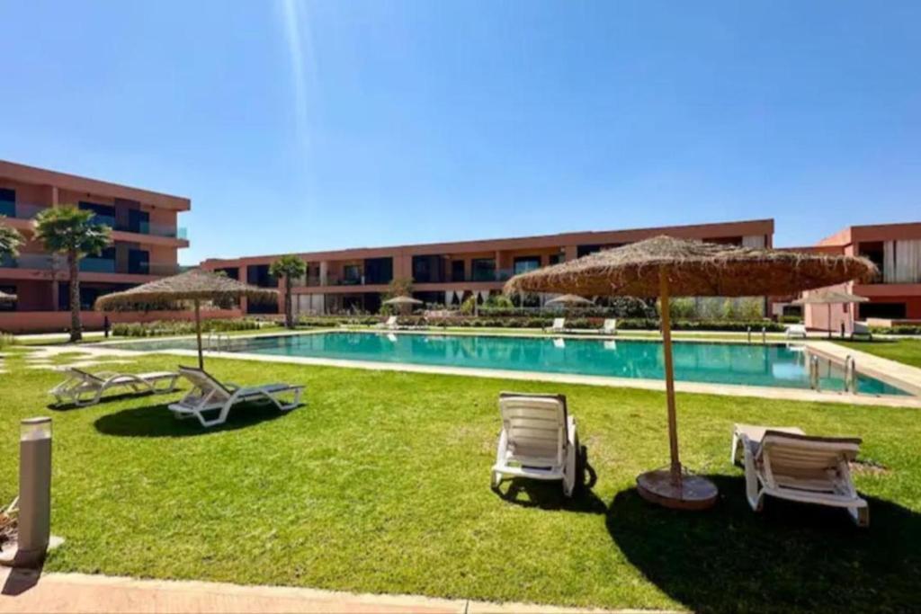 een zwembad met stoelen en parasols bij Noria Golf Marrakech in Marrakesh