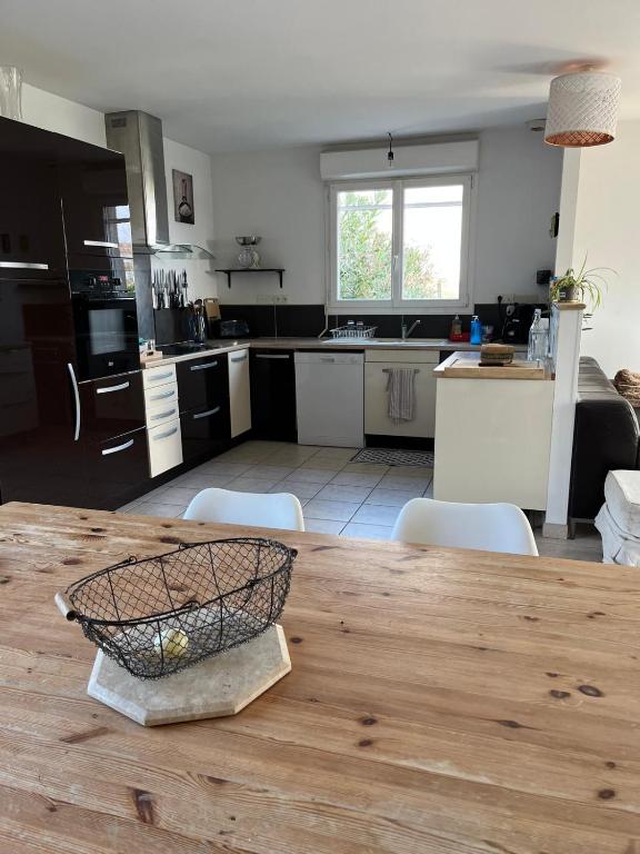 Il dispose d'une cuisine avec une table en bois et des chaises. dans l'établissement Évasion à 30 min de Toulouse, à Lagarde