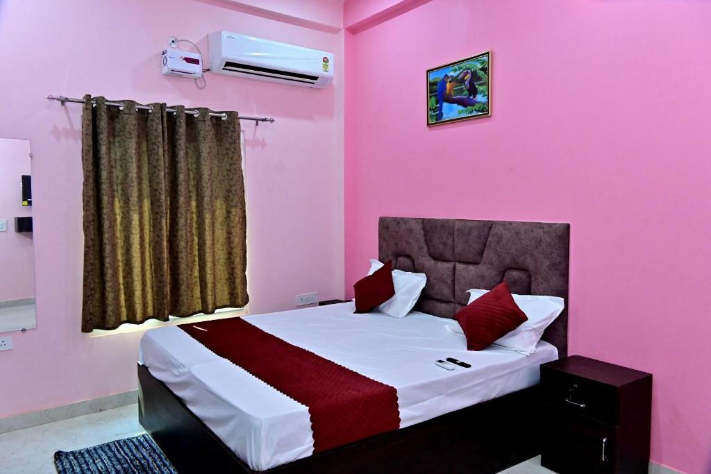 een slaapkamer met een groot bed met roze muren bij The Sunrise Ayodhya Guest House in Ayodhya