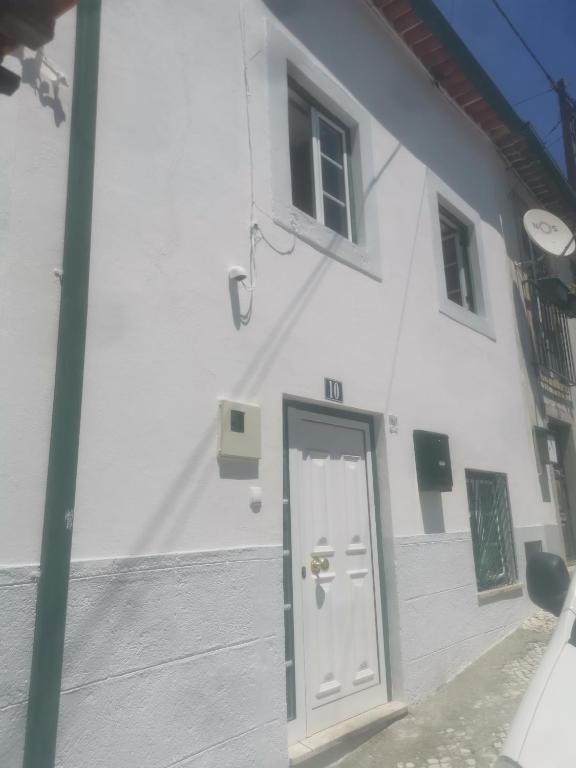 a white building with a door in front of it at Casa da Torre in Penela