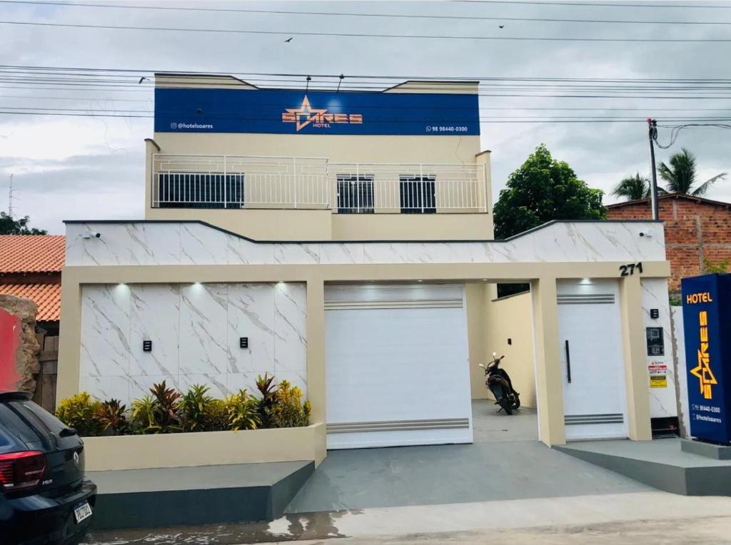 a building with two garage doors and a motorcycle parked in front at Hotel Soares in Anapurus
