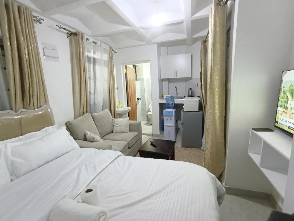 a bedroom with a white bed and a living room at Cities bnbs in Gatunga