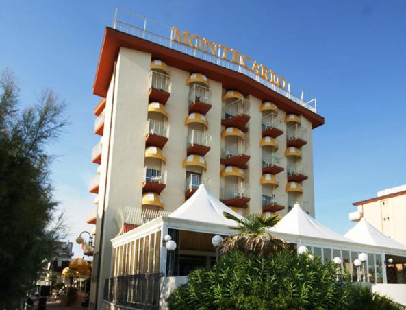 a hotel building with a balcony on top of it at Hotel Montecarlo in Lido di Jesolo