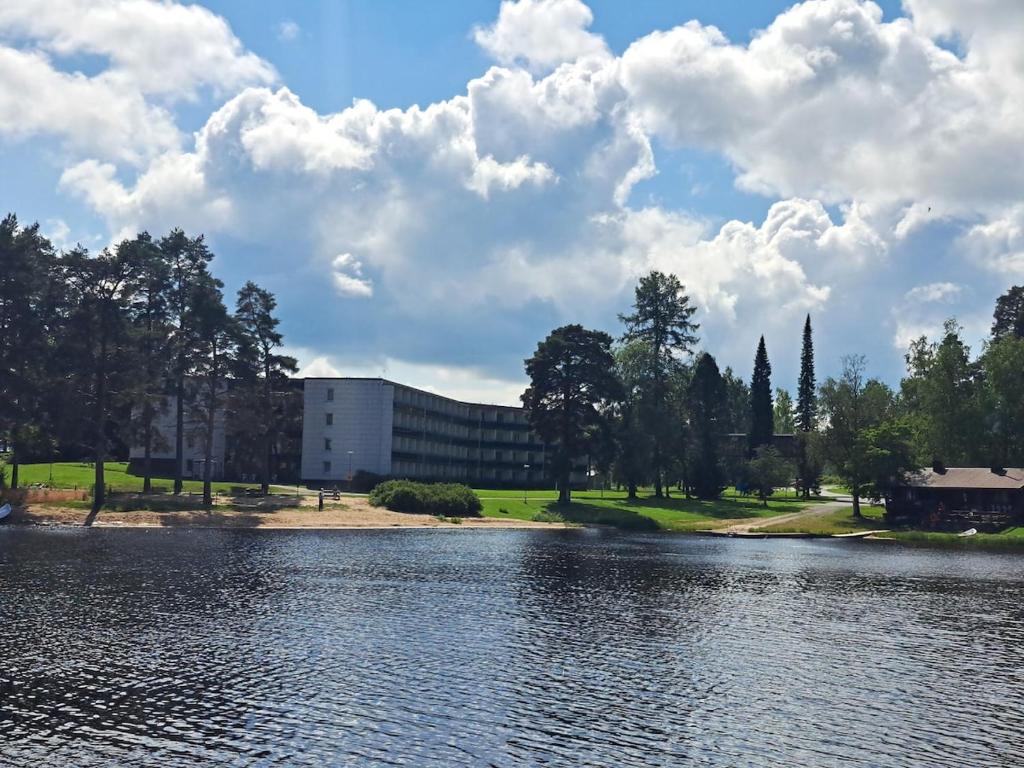 a building next to a body of water at Kylpylä-Hotelli, kahden huoneen huoneisto in Ikaalinen