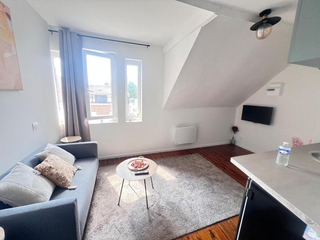 un salon avec un canapé et une table dans l'établissement Fleur de Liévin, à Liévin