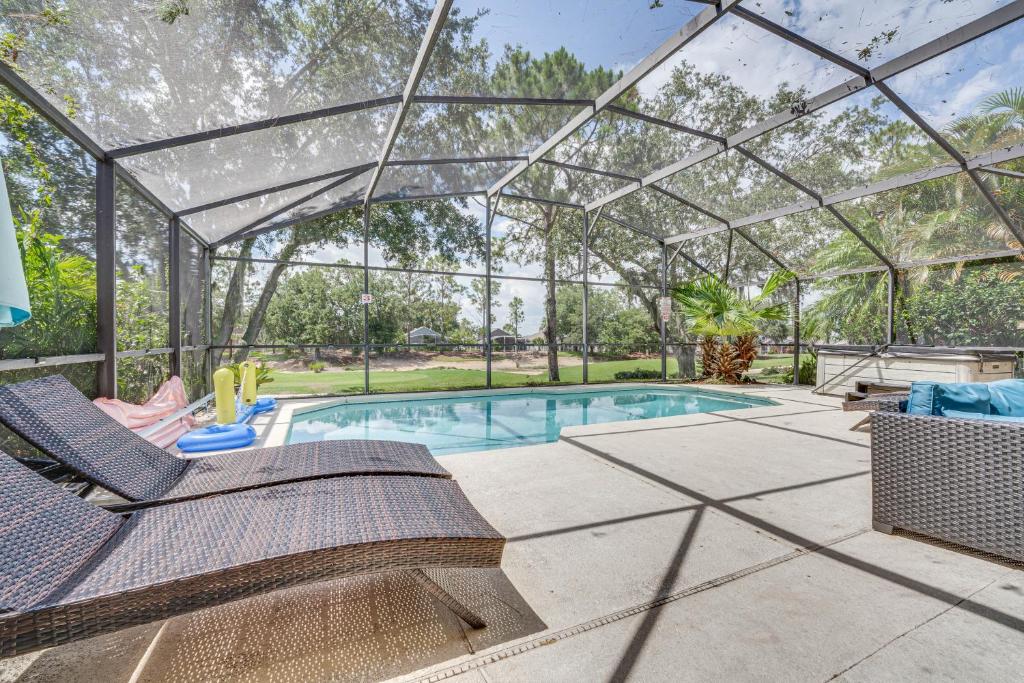 a swimming pool in a glass house with a patio at Southern Dunes Family Retreat Hot Tub and Game Room in Haines City