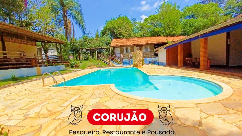 ein Swimmingpool vor einem Haus in der Unterkunft Pousada Corujão Quadra-SP in Quadra
