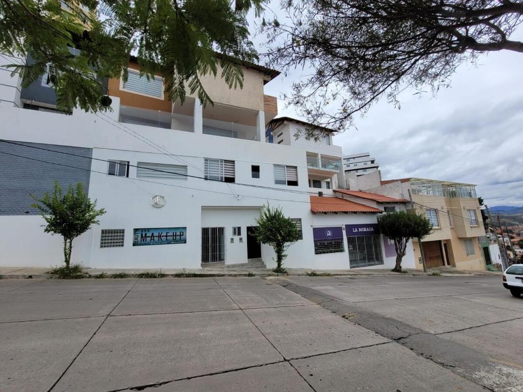 un edificio bianco con un parcheggio di fronte di Beautiful apartment a Sucre