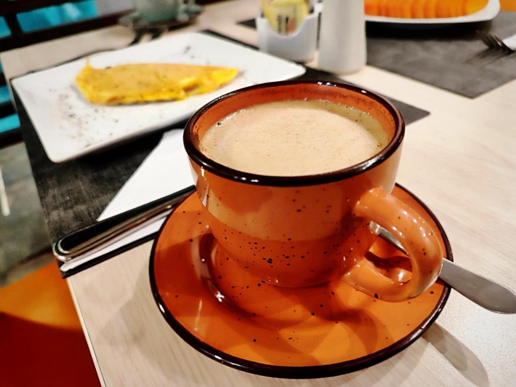 a cup of coffee on a plate on a table at Scala 68 in Bogotá