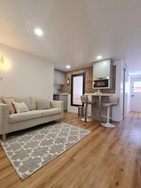 a living room with a couch and a desk at Alba Odeceixe - casa baixa in Odeceixe